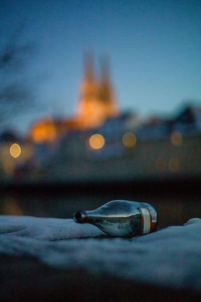 Bottle on wall with blurred building in background