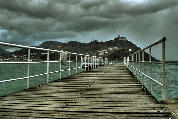 Jetty leading into the water, with land in the distance