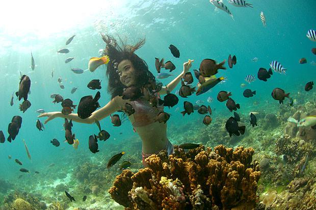 Woman dressed as mermaid surrounded by fish