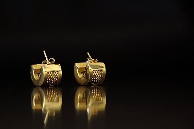 Pair of earrings on a reflective black surface