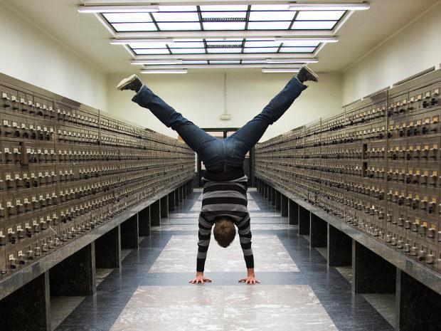 Man doing handstand in office